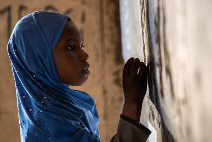 A girl writes on a board